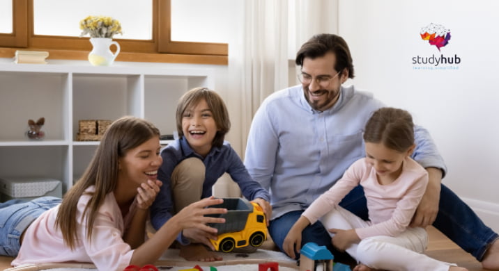 Happy parents playing with their children on the floor, demonstrating positive parenting skills and family bonding.