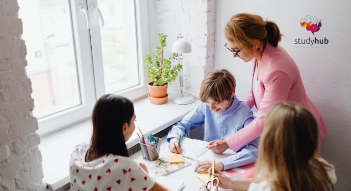 Activities coordinator supervising elderly residents painting during an arts and crafts session.