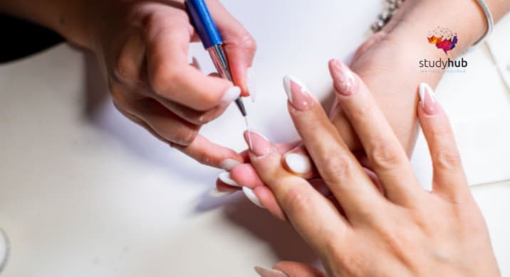 Nail technician applying acrylic nail enhancement to a client’s fingernail during a manicure session.
