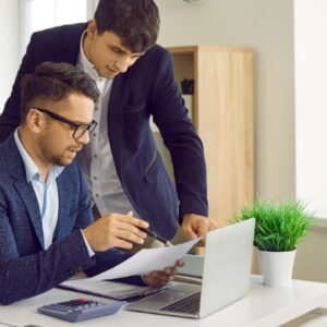 Two professionals collaborating over documents in a modern office environment.
