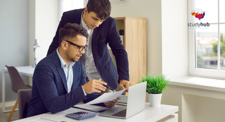 Two professionals collaborating over documents in a modern office environment.