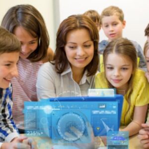 Primary school teacher guiding young children as they interact with digital learning content in a classroom.