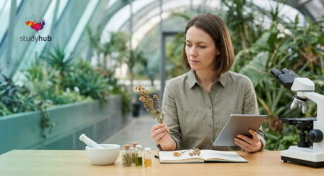 Ethnobotanist examining medicinal plants and documenting traditional herbal remedies in a botanical workspace.