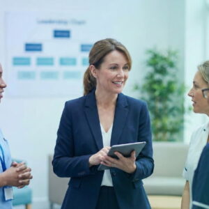 Senior healthcare manager reviewing operational strategies on a tablet in a modern UK hospital setting.