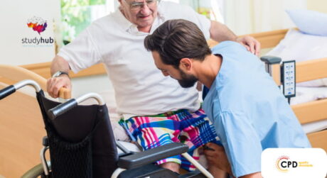 Healthcare professional assisting elderly man from wheelchair in hospital room