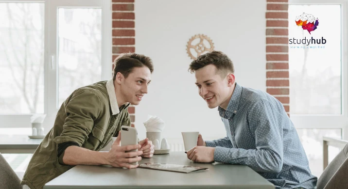 Two friends engaging in a lively conversation over coffee in a bright casual setting, representing the IsiXhosa: Everyday Conversation for Beginners course