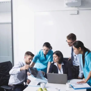 Healthcare professionals and administrators reviewing medical records and scans in a collaborative meeting, representing the Consent Training in Healthcare Course