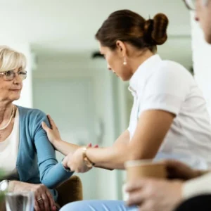 Caregiver providing compassionate support to an elderly woman in a home care setting, representing the Health and Social Care- Complete Bundle