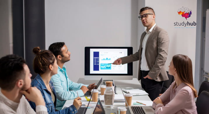 Technical lead presenting cloud application metrics to a team in a modern workspace, representing the Salesforce Heroku Masterclass