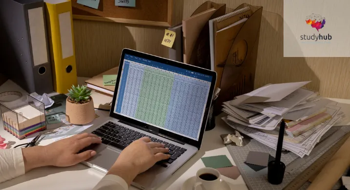 Close-up of hands typing on a laptop displaying a financial spreadsheet, surrounded by binders, receipts, and sticky notes, representing the Online Bookkeeping and QuickBooks Course