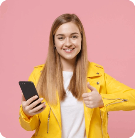 Smiling student in a yellow jacket holding a smartphone and giving a thumbs up for mobile learning