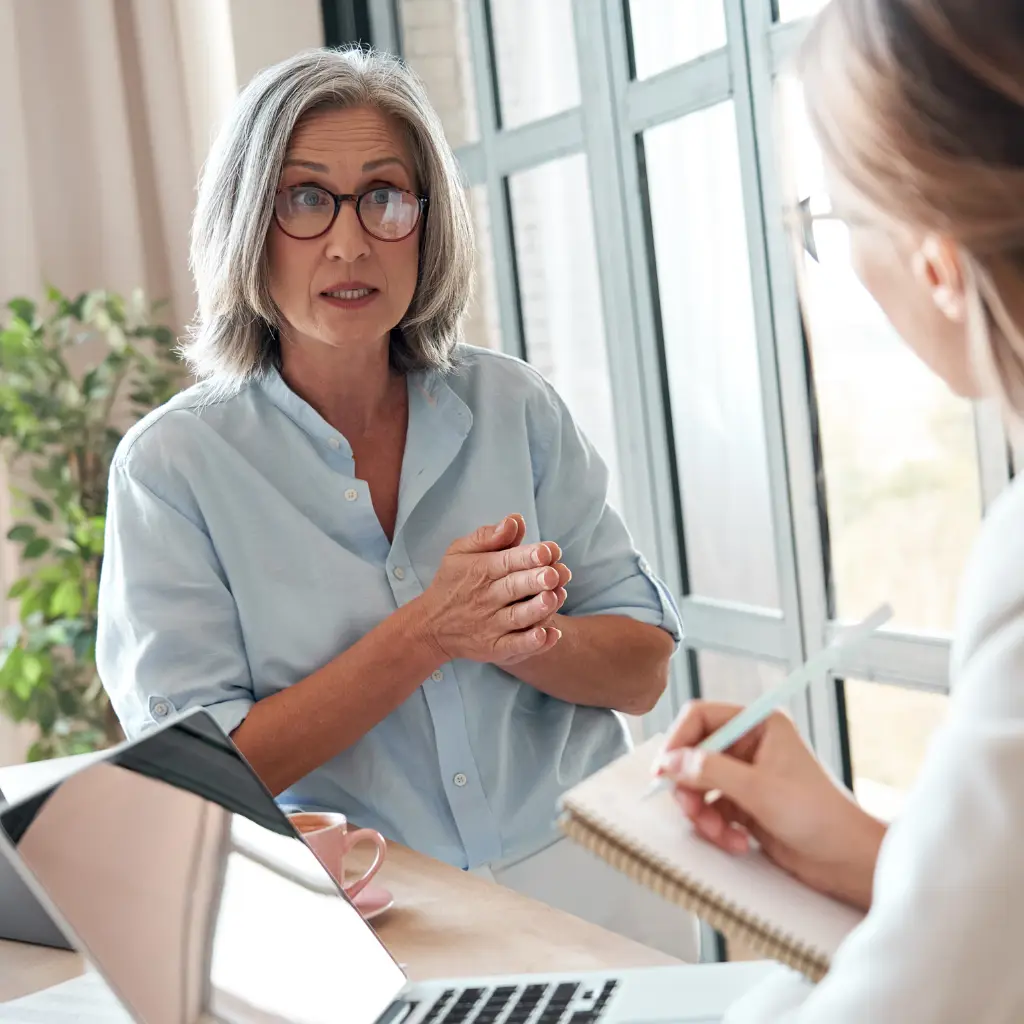 Senior woman speaking during a professional consultation meeting in a bright office.