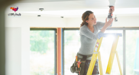 Close-up of a person adjusting layered clothing, showing a textured gray sweater, striped fabric, and blue garment with visible midsection.