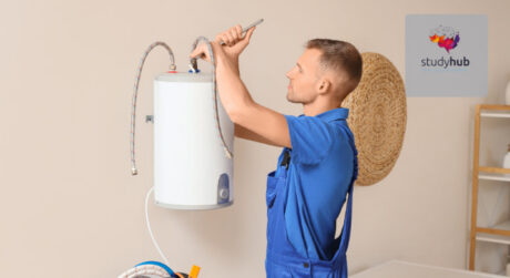 Plumber installing or repairing a wall-mounted water heater using tools in a modern home