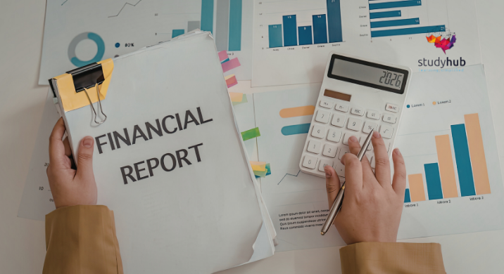 Coins stacked beside a glass jar, calculator, and model house on financial charts and reports