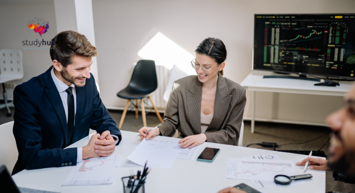 Two business professionals analyzing financial charts and discussing investment strategy in a modern office setting