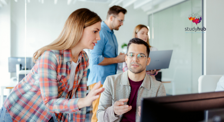 Stack of printed documents and forms with charts and tables partially visible on a desk