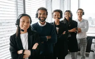 Diverse team of multilingual customer support professionals wearing headsets in a bright office